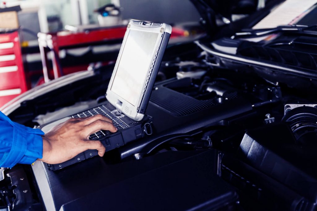 Mechanic using Diagnostic machine tools ready to be used with car